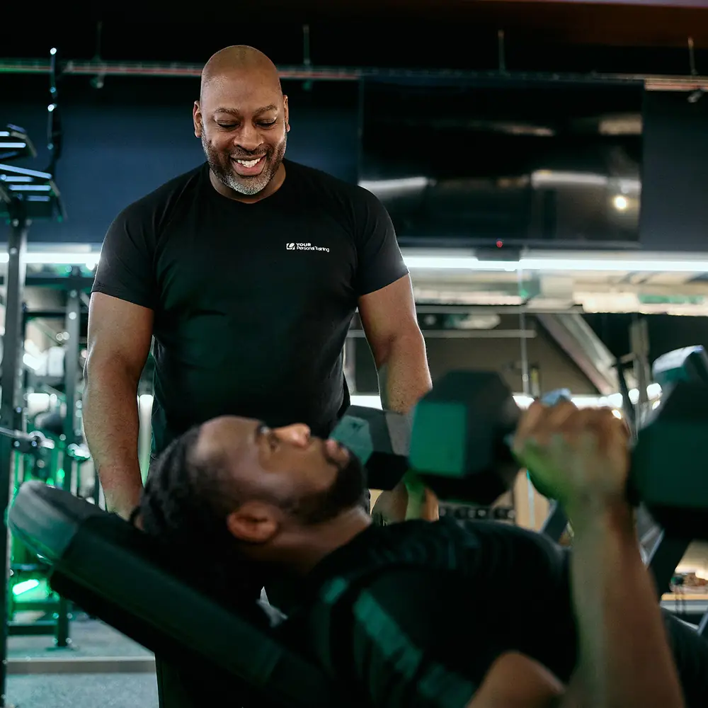 A YOUR Personal Training trainer on the gym floor with a member